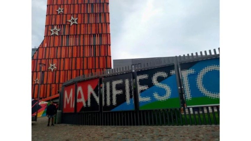 Elian de pie, en la entrada de su obra Manifiesto. Detrás, el imponente edificio de Casa Naranja en Córdoba