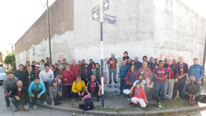 Vecinos, amigos y referentes de peñas de fútbol posan junto a la obra que realizaron los artistas Achaval y Daneri para rendir homenaje a Mario Latorre.